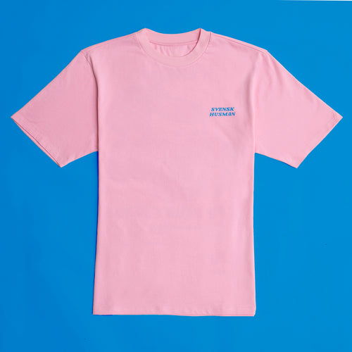 Hellrosa Oversize Tennis Semla T-Shirt aus Baumwolle mit Svenskhusman-Logo vor blauem Hintergrund.