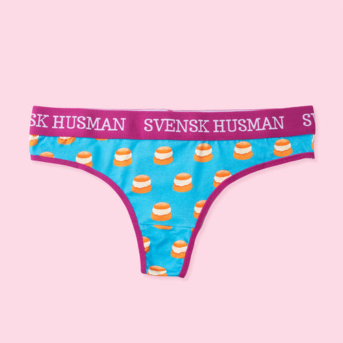 Blue cotton thong panties with a semla bun pattern and purple Svenskhusman elastic waistband.