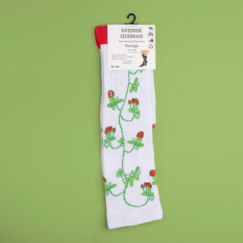 Vita stödstrumpor med mönster av röda jordgubbar och gröna blad från Svenskhusman.
