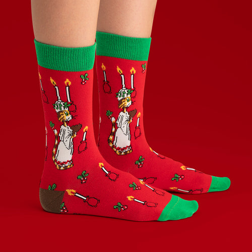 Röda barnstrumpor med juligt motiv av Findus som Lucia och gröna muddar från Svenskhusman.