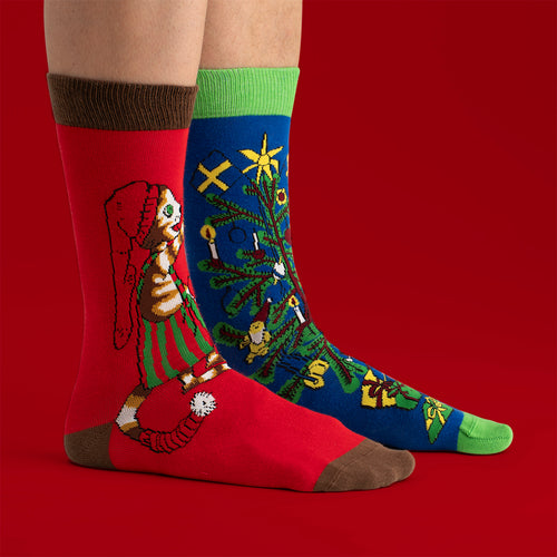 Röda och blå julstrumpor med motiv av Findus som pyntar granen, från Svenskhusman.