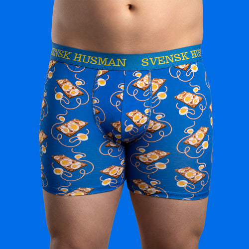 Blå boxerkalsonger med mönster av kaviarmacka och ägg på en herrmodell från Svenskhusman.