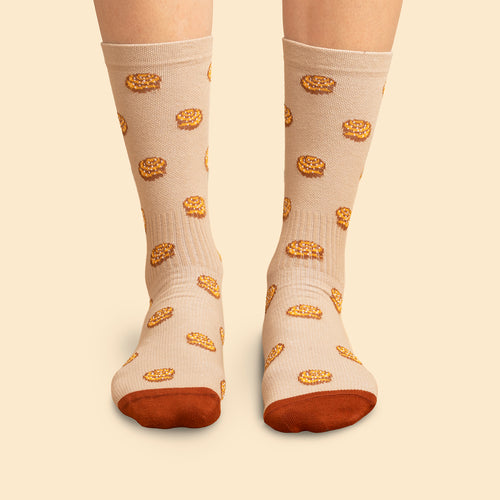 Beige stödSocken i sneakersmodell med mönster av kanelbullar och brauna tår från Schwedischhusman.