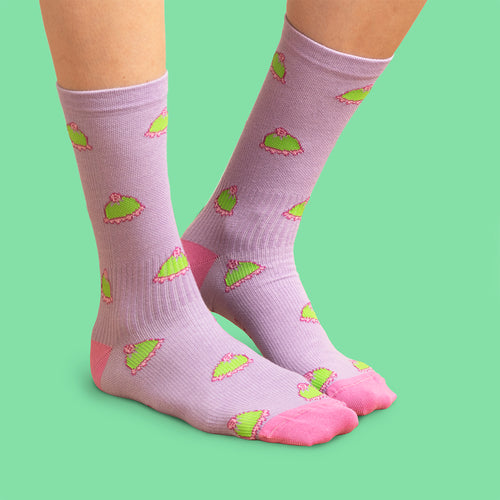 Lila stödSocken med mönster av prinsesstårtor och rosa detaljer på grün bakgrund från Schwedischhusman.