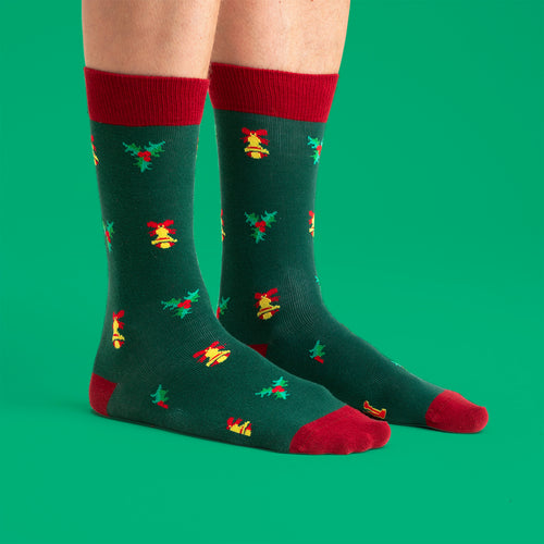 Gröna julstrumpor med mönster av klockor och järnek från motivet Say Mama - Svenskhusman.