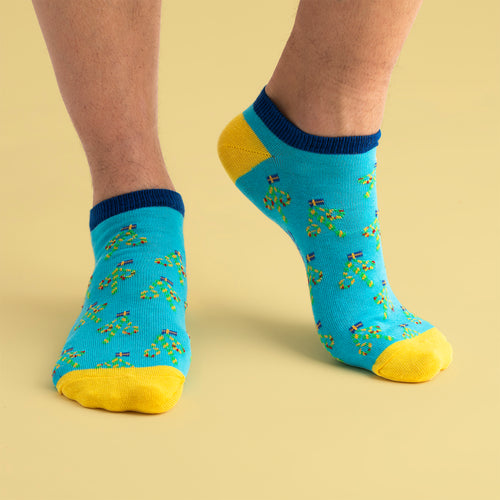 Ljusblå sneakersstrumpor med mönster av midsommarstänger och gula detaljer på fötter från Svenskhusman.