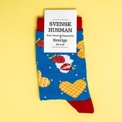 Blå barnstrumpor dekorerade med hjärtformade våfflor och jordgubbar från märket Svenskhusman.