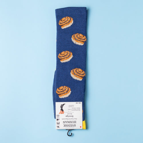 Blå støttestrømper med mønster af kanelsnegle fra Svenskhusman på en lyseblå baggrund.