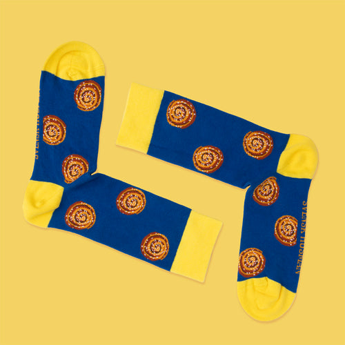 Blau-gelbe Socken mit Zimtschnecken-Muster auf gelbem Hintergrund von Svenskhusman.