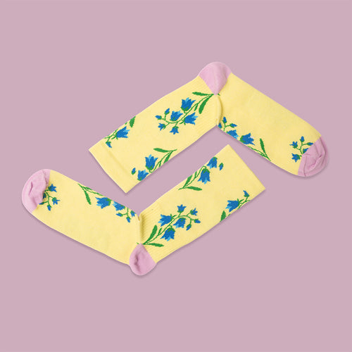 Yellow compression socks with bluebell patterns and pink accents from Svenskhusman.