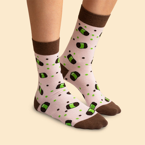 Pink patterned socks featuring vacuum cleaner pastries and brown cuffs on feet from Svenskhusman.