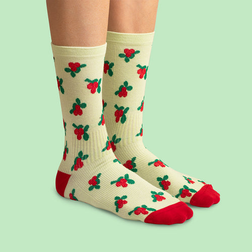 Compression socks featuring a red lingonberry pattern and details on a pale yellow base by Svenskhusman.