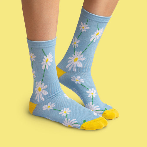 Light blue daisy compression socks with yellow accents and white floral patterns by Svenskhusman.