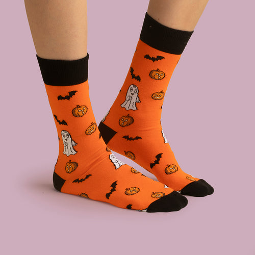Orange strumpor med Spöket Laban, pumpor och fladdermöss samt svarta muddar och tår på fötter från Svenskhusman.