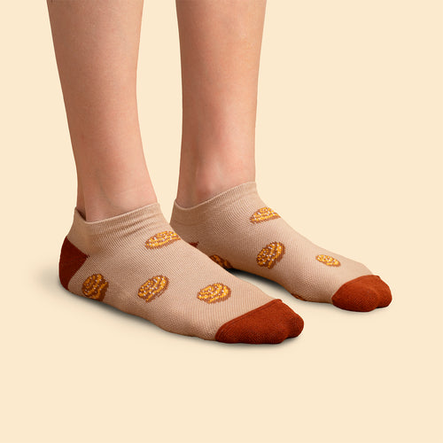 Låga beige sneakers-stödstrumpor med mönster av kanelbullar på en modell - Svenskhusman.