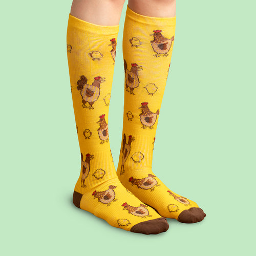 Yellow compression socks with an Easter chick and hen pattern by Svenskhusman.