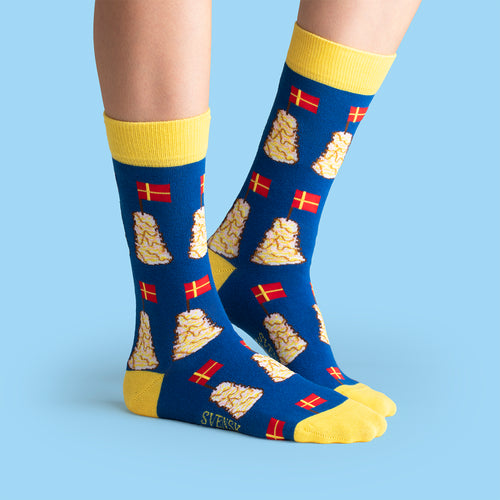 Blue and yellow socks featuring a pattern of spettekaka cakes and Swedish flags by Svenskhusman.