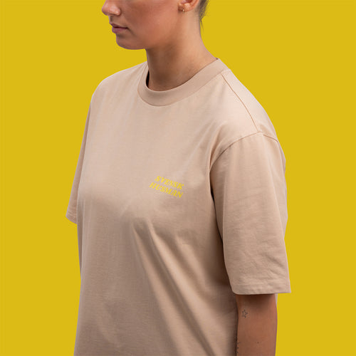 Beige oversize T-shirt i kraftig bomull med gul logotyp, modell Football Kanelbulle från Svenskhusman.