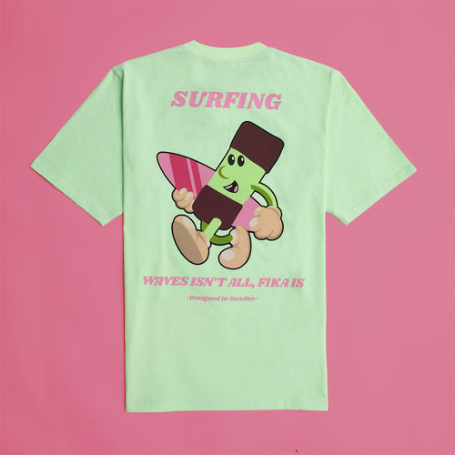 Ljusgrön t-shirt i bomull prydd med en surfande dammsugare och text om fika på ryggen.