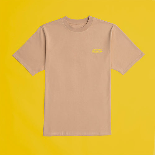 Beige Football Kanelbulle T-shirt från Svenskhusman i mjuk bomull mot gul bakgrund.