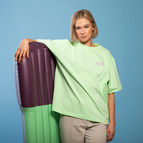 Hellgrünes Oversize-T-Shirt aus Baumwolle mit Surf-Staubsauger-Motiv an einem Modell – Svenskhusman