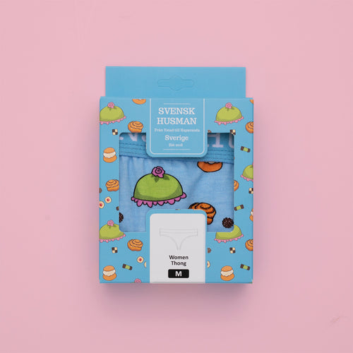 Light blue packaging with a fika pattern for baby blue thongs from Svenskhusman on a pink background.