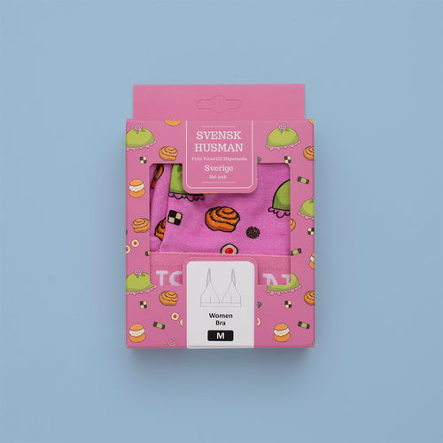 Rosa BH med fika-mönster av kanelbullar och bakelser i förpackning från Svenskhusman.