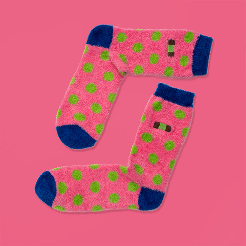Pink fluffy socks with green polka dots, blue accents, and Swedish dammsugare pastry motifs by Svenskhusman.