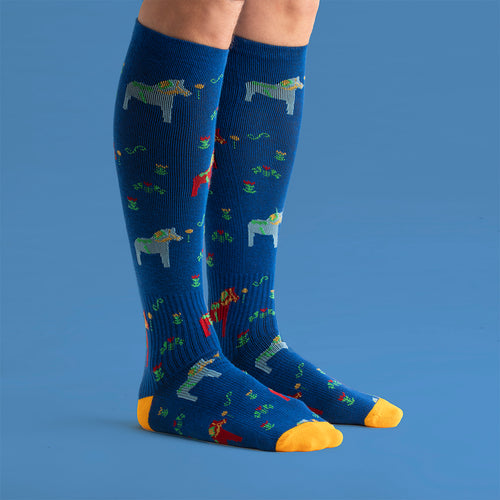 Blue knee-high support socks with a colorful Dala horse pattern and yellow details from Svenskhusman.