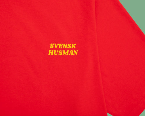 Rotes Skiing Lussebulle T-Shirt aus Baumwolle mit gelbem Svenskhusman-Logo auf der Brust.