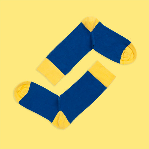 Blue and yellow seamless contrast socks with yellow heels and toes on a yellow background from Svenskhusman.