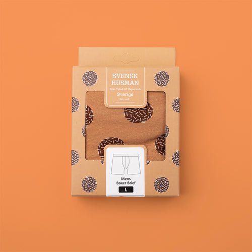 Svenskhusman boxer briefs with a chocolate ball pattern in a stylish gift box on an orange background.