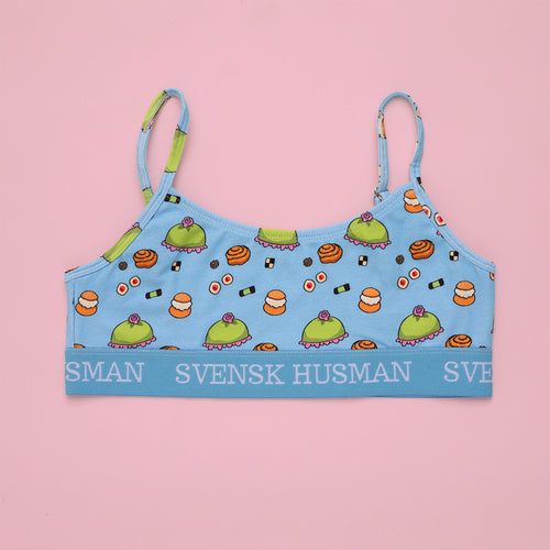 Babyblå BH-topp med fika-mönster av bakverk och resårband med Svenskhusman-logotyp.