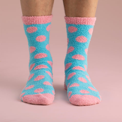 Fluffy light blue socks with a pink semla pattern worn on feet by Svenskhusman.