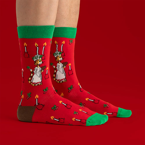 Röda och gröna julstrumpor med Findus som Lucia från Svenskhusman, dekorerade med stämningsfulla ljus.