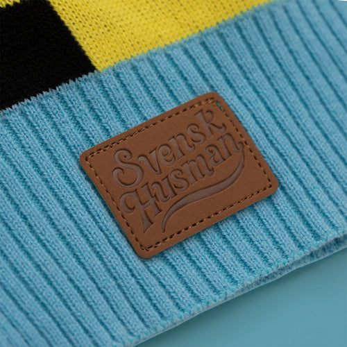 Brown leather patch with the Svenskhusman logo on the knitted 