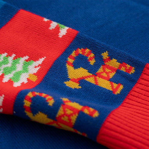 Blue and red knitted Svenskhusman Christmas sweater featuring a pattern of drink glasses and fir trees.