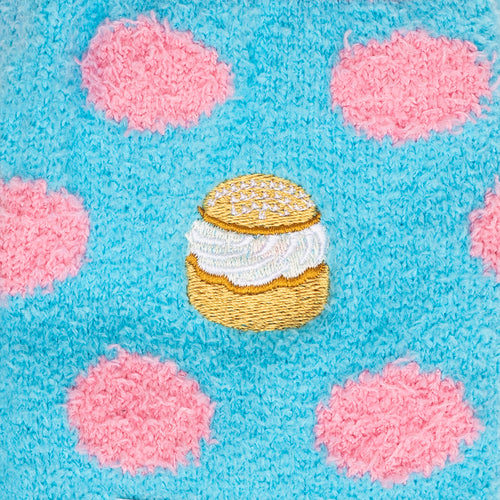 Fluffy light blue socks with pink dots and a detailed embroidered semla from Svenskhusman.