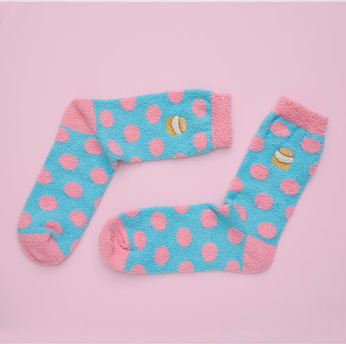 Fluffy light blue socks with pink polka dots and an embroidered semla motif by Svenskhusman.