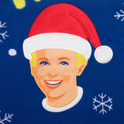 Blauer Strick-Weihnachtspullover von Svenskhusman mit Kalles Kaviar-Junge in Weihnachtsmütze und Schneeflocken.
