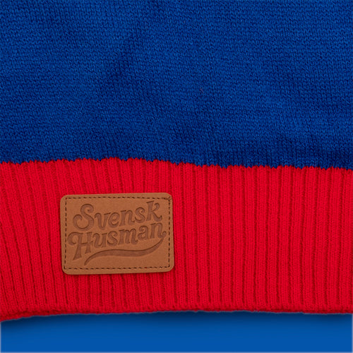 Blau-roter gestrickter Weihnachtspullover im Kalles Kaviar Design mit Svenskhusman-Logo auf einem Lederpatch.