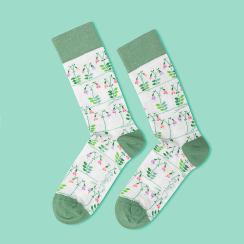 Vita och gröna Stig L Linnea-strumpor med blommigt mönster av Stig Lindberg från Svenskhusman.