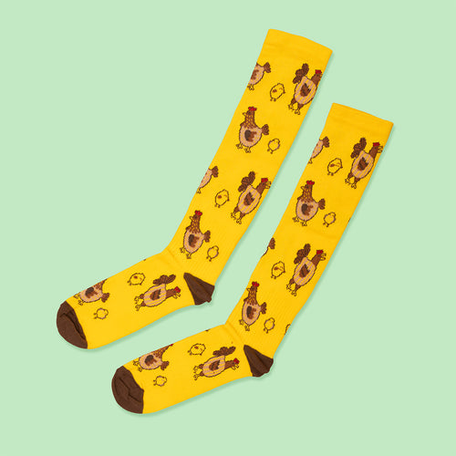 Yellow compression socks with a playful pattern of Easter chicks and brown hens by Svenskhusman.