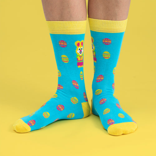 Light blue and yellow socks with Easter bunny and egg patterns by Svenskhusman on a yellow background.