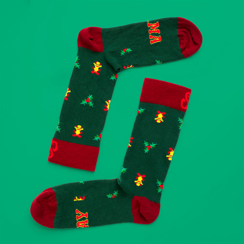 Grønne julestrømper med motiv af gule klokker og citatet SAY MAMA fra Svenskhusman.