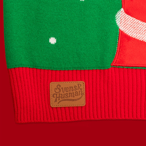 Grön stickad jultröja med röd mudd och brun logopatch från Svenskhusman.