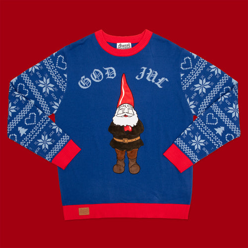 Blå jultröja med hustomte, texten God Jul och röda muddar från Svenskhusman på röd bakgrund.