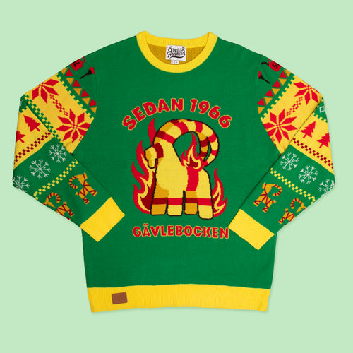 Grön stickad jultröja med motiv av den brinnande Gävlebocken och gula detaljer från Svenskhusman.