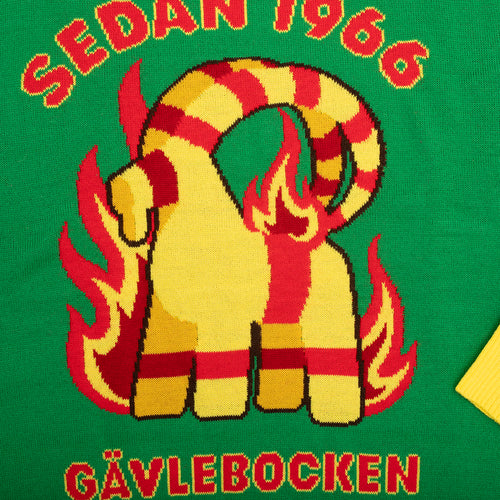 Grön stickad jultröja med motiv av den brinnande Gävlebocken och texten Gävlebocken från Svenskhusman.