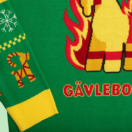 Grön stickad jultröja med motiv av Gävlebocken och gula detaljer från Svenskhusman.